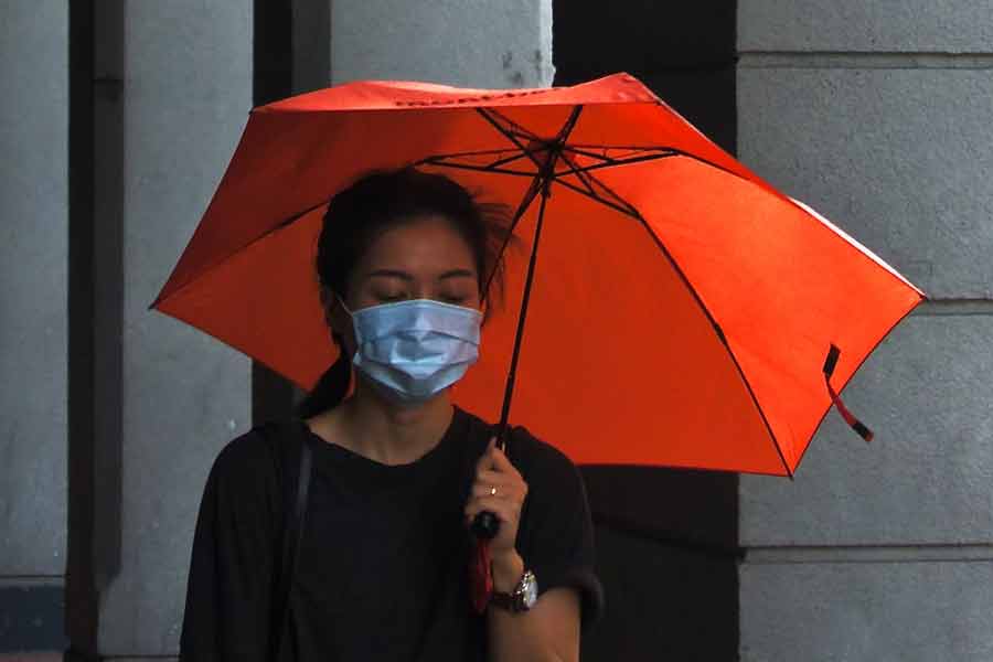 Perempuan Wan Chai, Hong Kong, melintas dengan masker saat pandemi Covid-19 (foto: Tam Wai | unsplash)
