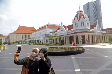 Dua remaja berfoto di Alun-alun Kota Surabaya, lokasi puncak gelaran Anugerah Pewarta Foto Indonesia (APFI) 2023